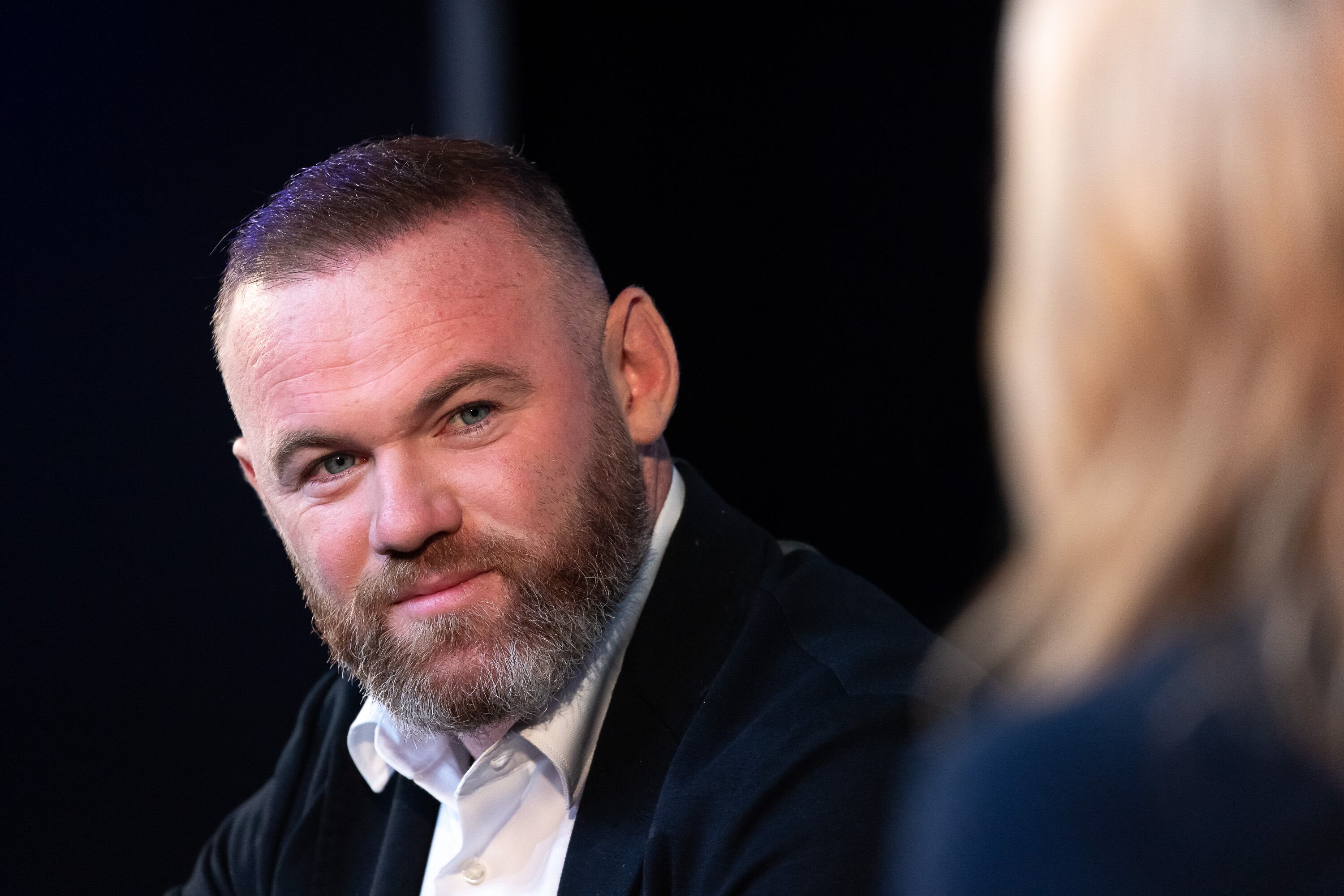 LONDON, ENGLAND - OCTOBER 12: Wayne Rooney speaking with Gabby Logan on stage at the 'Prime Video Presents Sport' event at Pan Pacific on October 12, 2021 in London, England.  At the event a series of announcements were revealed, including the Amazon Original documentary on the life and career of Wayne Rooney and Lioness: The Nicola Adams Story.  (Photo by Tim P. Whitby/Tim P. Whitby/Getty Images for Amazon Prime)