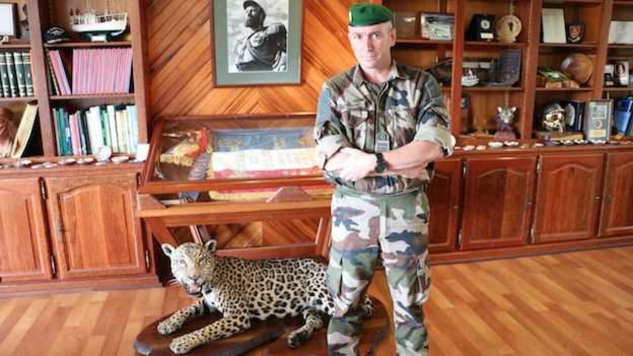 El coronel Jérôme Ransan, en su despacho junto a un jaguar embalsamado y la bandera del tercer Regimiento extranjero de infantería que comanda en la Guyana Francesa,.