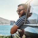 Foto de un joven disfrutando de un viaje por carretera