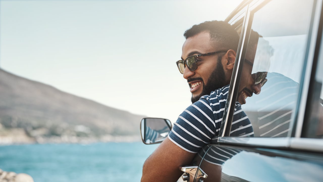 Foto de un joven disfrutando de un viaje por carretera