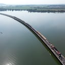 Esta fotografía aérea tomada el 4 de noviembre de 2023 muestra a turistas que viajan a bordo del popular "tren flotante" tomando fotografías a lo largo de las vías del tren durante una parada en medio de la presa Pasak Jolasid, el embalse más grande de Tailandia en la provincia de Lopburi. Un barquero solitario observó el espectáculo del llamado "tren flotante" de Tailandia mientras los pasajeros en busca de selfies disfrutaban de las vistas del agua después de desembarcar de los vagones detenidos en un puente estrecho.