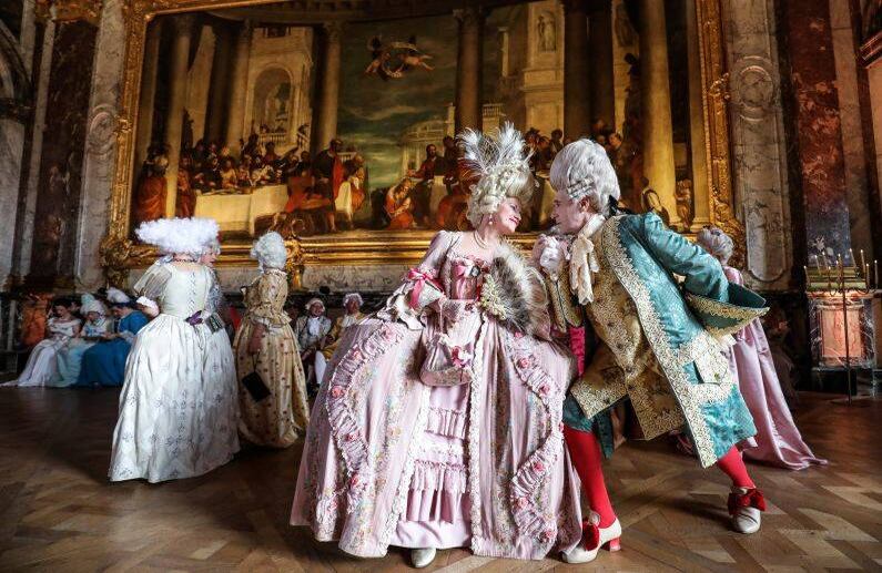 27 de mayo - Una pareja veneciana italiana vestida con trajes de época posa mientras participan en la noche de disfraces "Fetes Galantes" en el Chateau de Versailles.  FOTO: Ludovic MARIN / AFP