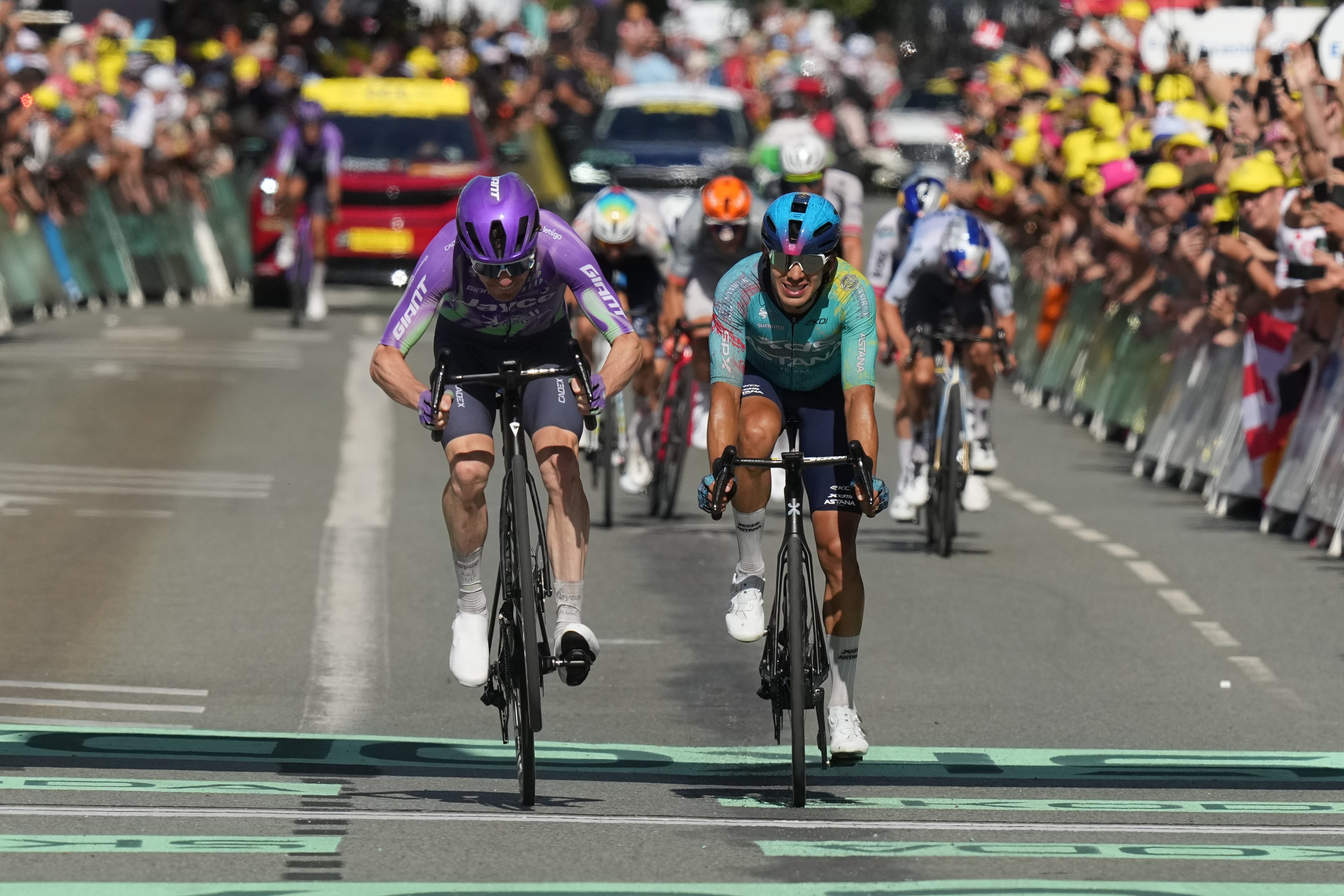 Switzerland's Mauro Schmid, left, crosses the finish line ahead of Colombia's Harold Tejada, right, to win the thirteenth stage of the Tour de France cycling race with start in Dole and finish in Belfort, France, Friday, July 17, 2026. (AP Photo/Thibault Camus)
