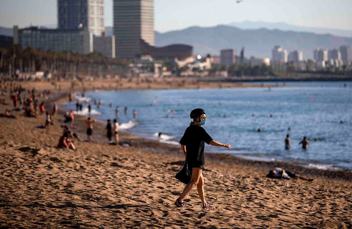 La gente disfruta de la playa en Barcelona, España, miércoles 20 de mayo de 2020. El gobierno de Barcelona avaló el miércoles que la gente camine por sus playas por primera vez desde el comienzo del bloqueo del coronavirus hace más de dos meses. (Foto AP / Emilio Morenatti)