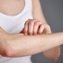 Mujer rascando su brazo