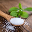 Old wooden table with Stevia Granules (selective focus; close-up shot)