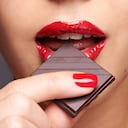 Closeup portrait of a cute young female biting into a piece of chocolate