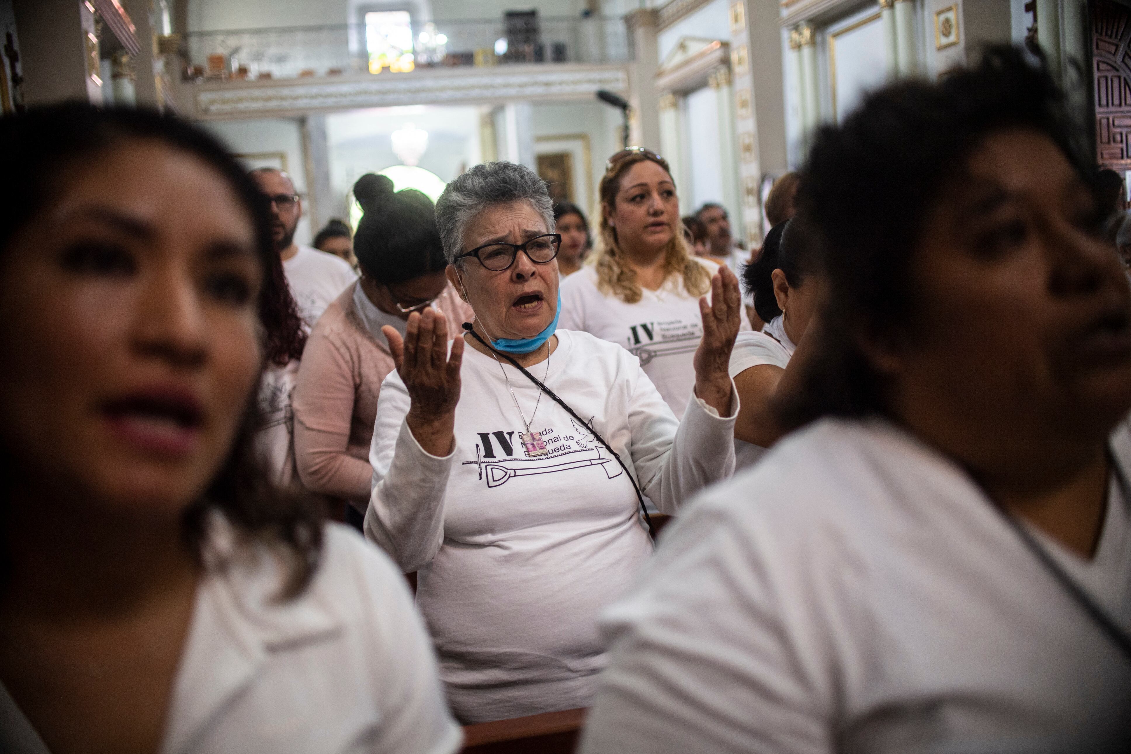 La mexicana María Herrera, quien busca a cuatro hijos desaparecidos, sostiene sus retratos durante una marcha como parte de las actividades de la Cuarta Brigada Nacional de Búsqueda, en Huitzuco de los Figueroa, Guerrero. estado, México. - María Herrera vivió una vida feliz vendiendo ropa en un mercado de México, hasta que cuatro de sus hijos desaparecieron en dos incidentes, en medio de una incesante ola de violencia. Ahora es una "fiera" que busca las huellas de sus hijos y un emblema para miles de familiares de desaparecidos. (Foto de Pedro PARDO / AFP)
