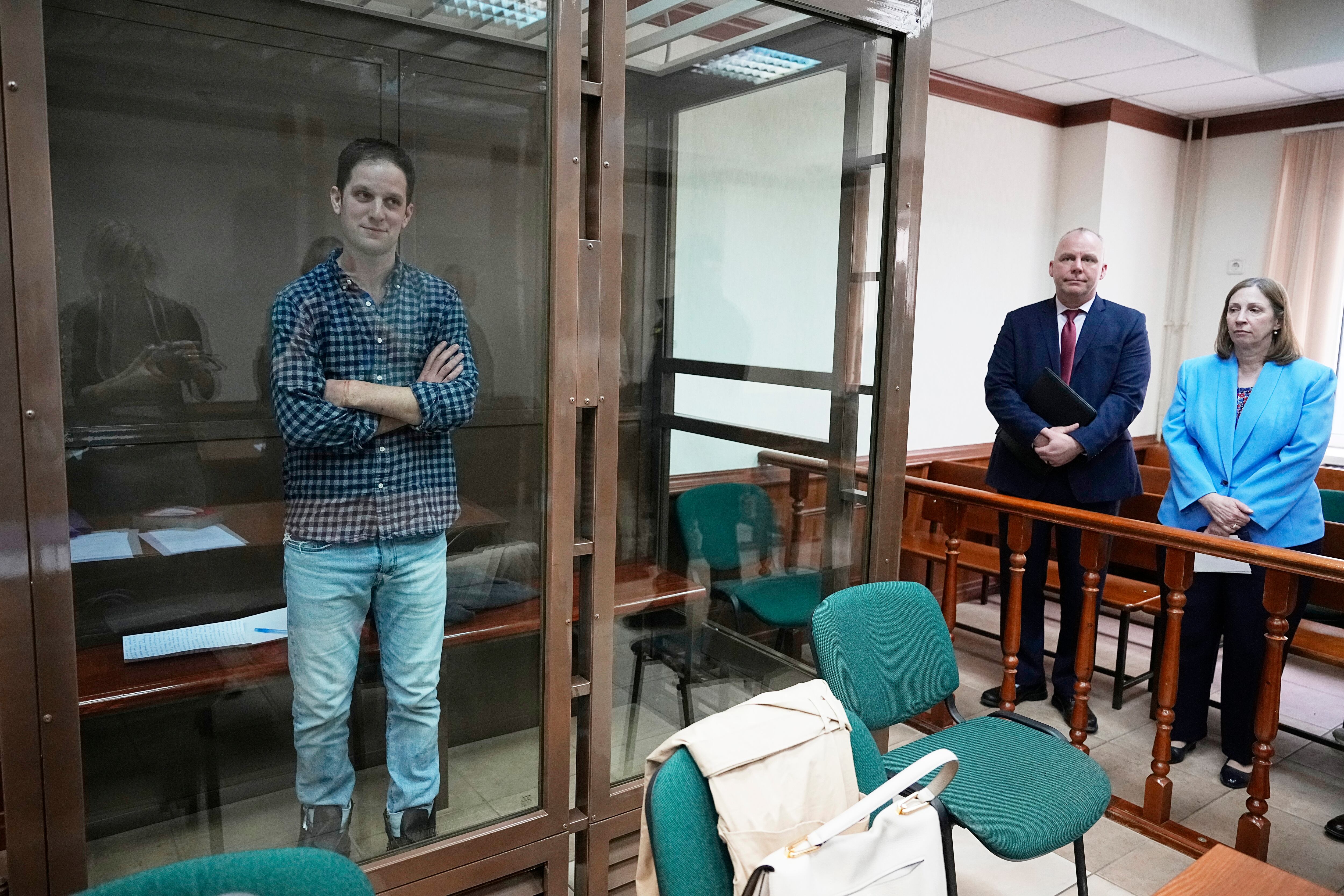 El reportero del Wall Street Journal, Evan Gershkovich, se encuentra en una jaula de vidrio en una sala del tribunal de la ciudad de Moscú, La embajadora de Estados Unidos en Rusia, Lynne Tracy, se encuentra a la derecha.