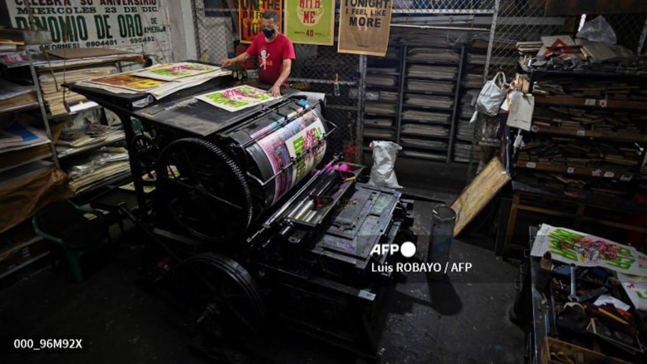 Olmedo Franco, 62, prints posters in a 1890 New York�s Reliance printing press, inside the La Linterna printing house in Cali, Colombia, on March 2, 2021. - In the heart of the colonial district of Cali, the La Linterna printing house was slowly dying out until graphic designers and street artists rekindled this beacon of traditional typography. (Photo by Luis ROBAYO / AFP)