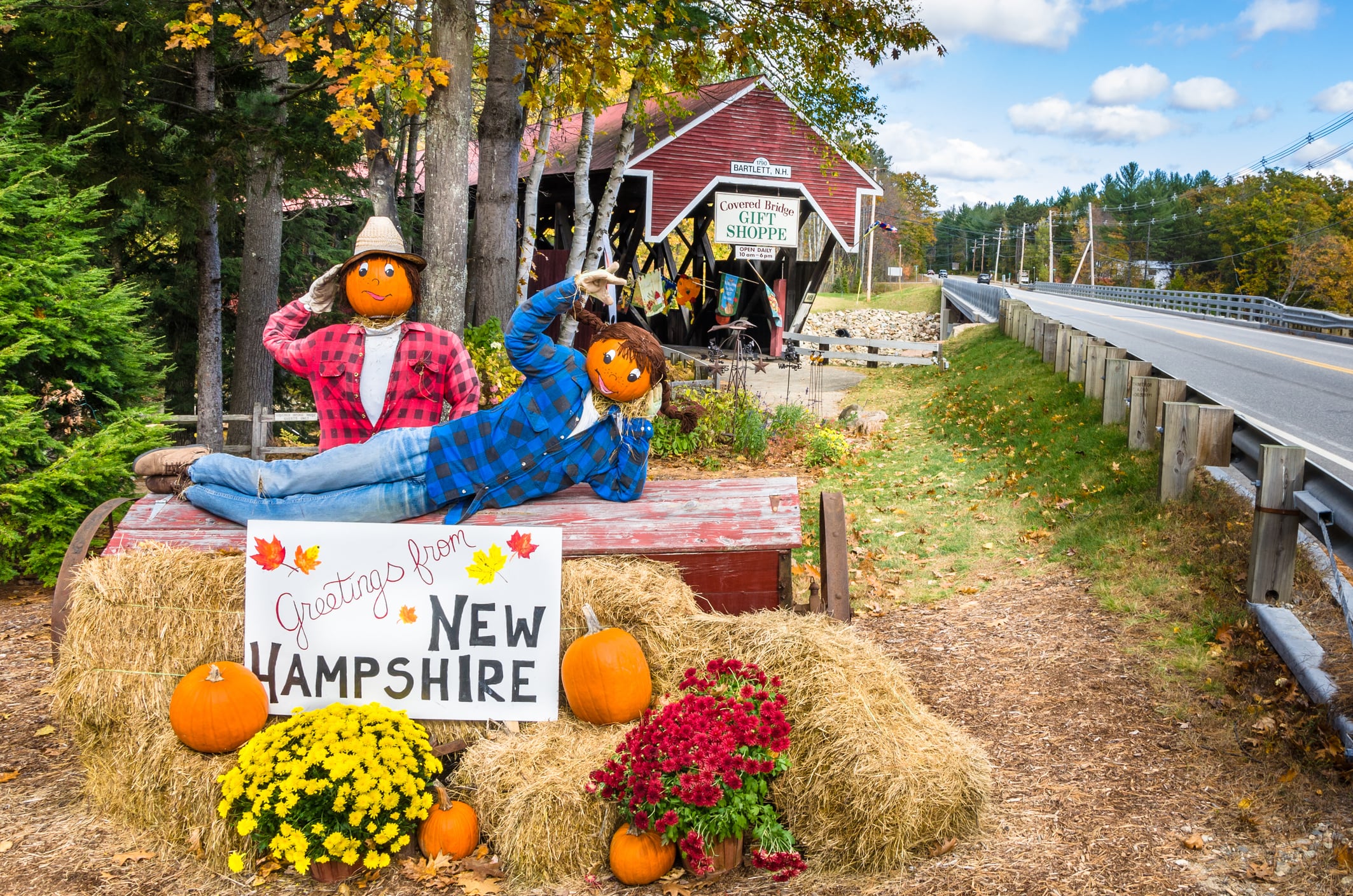 Bartlett, NH, EE.UU. - 12 de octubre de 2012: Decoración de Halloween frente a la tienda de regalos Covered Bridge. El histórico puente cubierto Bartlett, que cruza el río Saco, es uno de los 53 puentes cubiertos que quedan en New Hampshire. El puente cubierto Bartlett se construyó en 1851, pero ya no se utiliza para el paso de vehículos. El puente es de propiedad privada y está abierto al tráfico peatonal. El puente cubierto de Bartlett también ofrece una tienda de regalos dentro del puente.