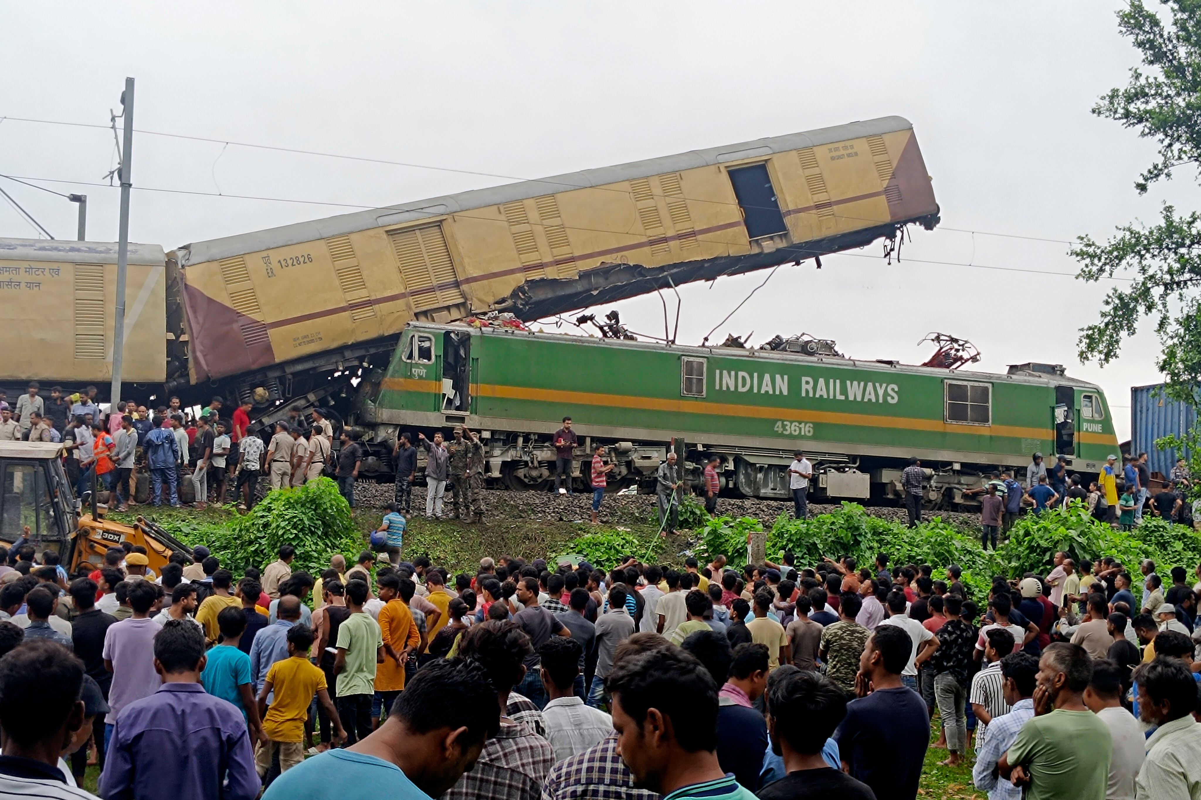 Los espectadores observan mientras los rescatistas trabajan después de que un tren de carga chocó contra Kanchanjunga Express, un tren de pasajeros, cerca de la estación New Jalpaiguri, estado de Bengala Occidental, India, el lunes 17 de junio de 2024. (Foto AP/Diptendu Dutta)
