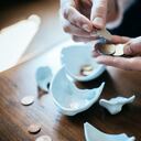 Hands counting coins from a broken piggy bank.
