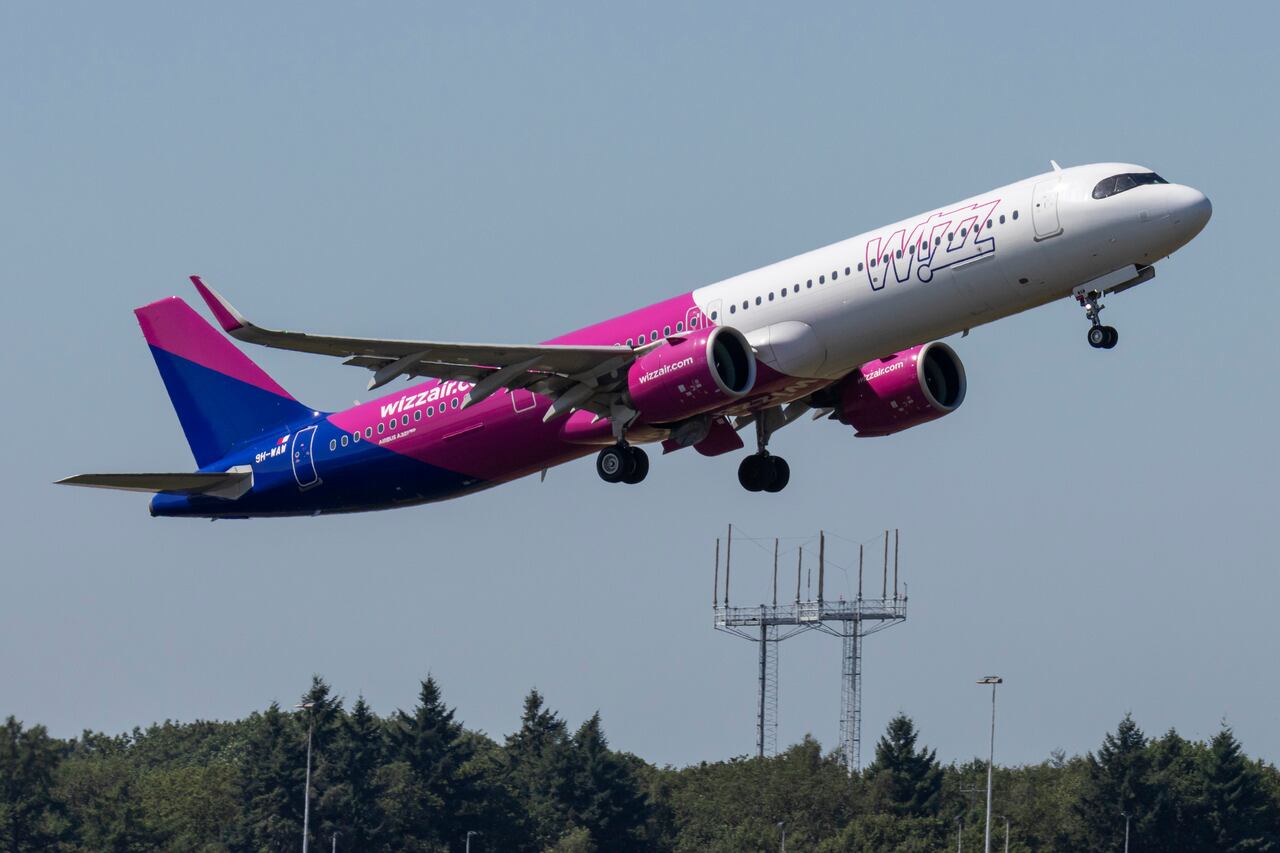 Avión Airbus A321 neo de Wizz Air Malta visto en el aeropuerto de Eindhoven durante la fase de rodaje, despegue y vuelo en el cielo azul. El avión de pasajeros A321NEO con matrícula 9H-WAW de la aerolínea de bajo coste despega hacia el aeropuerto internacional de Katowice KTW, en Polonia.