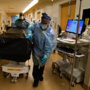 Unos trabajadores de salud llevan un paciente que falleció a causa del COVID-19 en el Providence Holy Cross Medical Center en la sección de Mission Hills de Los Ángeles, el sábado 9 de enero de 2021. (AP Foto/Jae C. Hong)