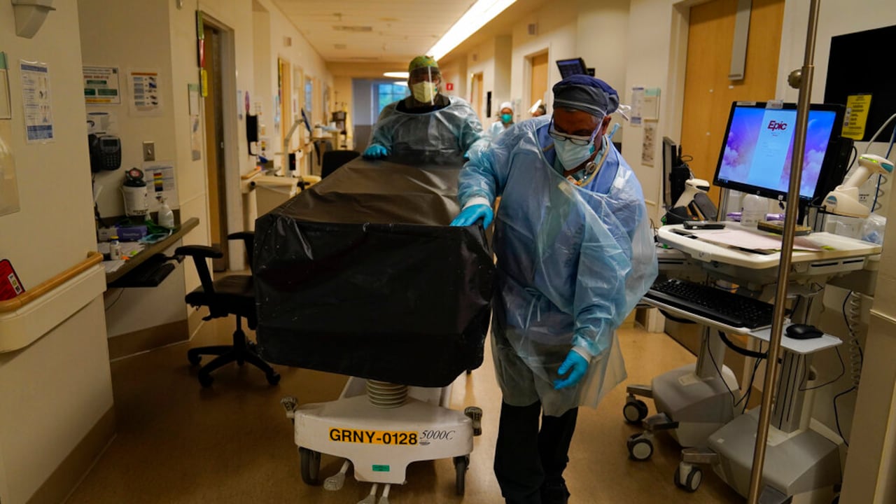 Unos trabajadores de salud llevan un paciente que falleció a causa de la covid-19 en el Providence Holy Cross Medical Center en la sección de Mission Hills de Los Ángeles, a principios de 2021. AP Foto/Jae C. Hong)