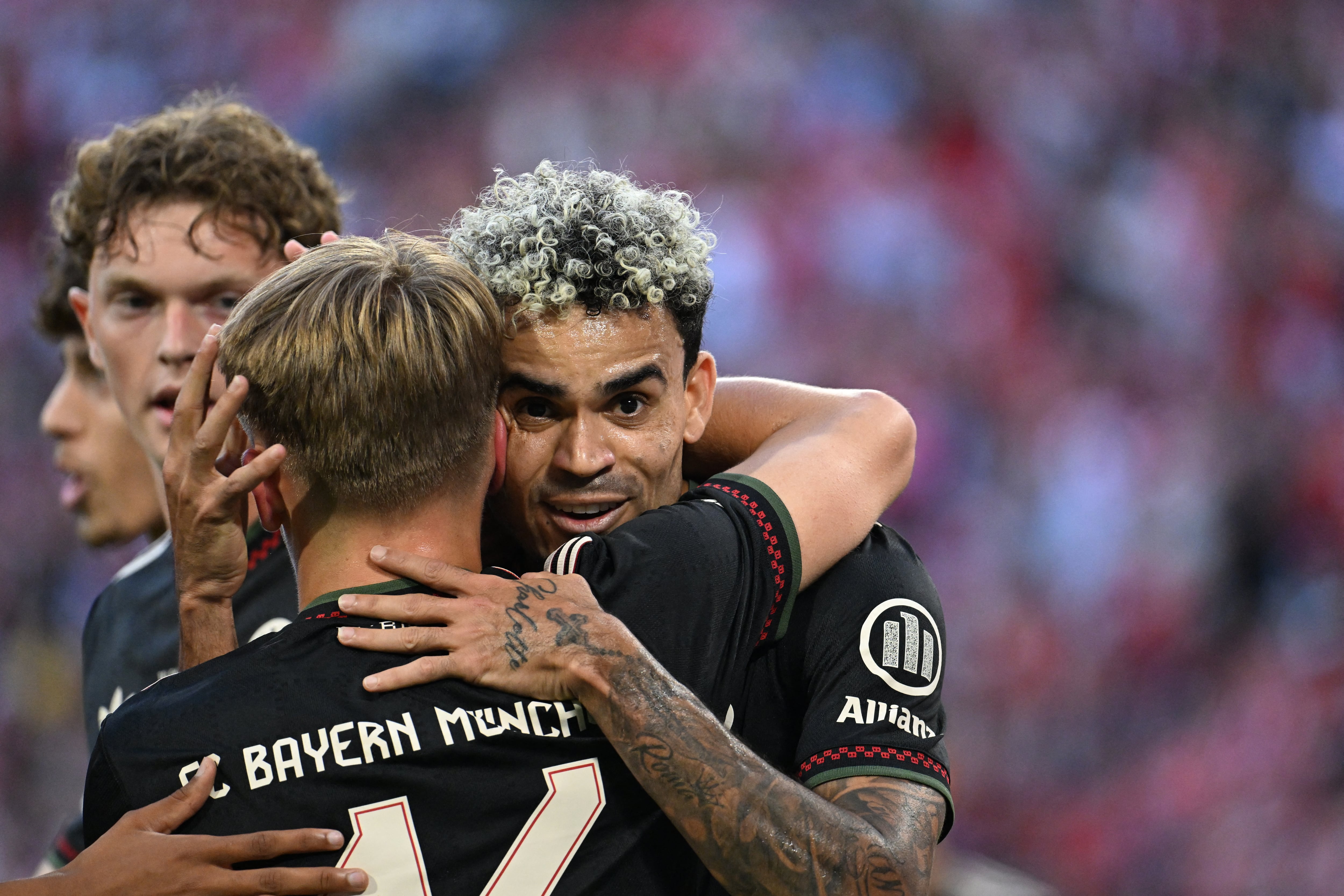 Bayern Munich's German midfielder #46 Karl Lennart (C) celebrates scoring the 3-0 goal with Bayern Munich's Colombian forward #14 Luis Diaz (R) during a friendly football match between FC Bayern Munich and Tottenham Hotspur in Munich, southern Germany, on August 7, 2025. (Photo by LUKAS BARTH-TUTTAS / AFP)