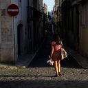 Una mujer camina por una calle mientras se pone el sol en Lisboa. (Foto AP / Armando Franca)