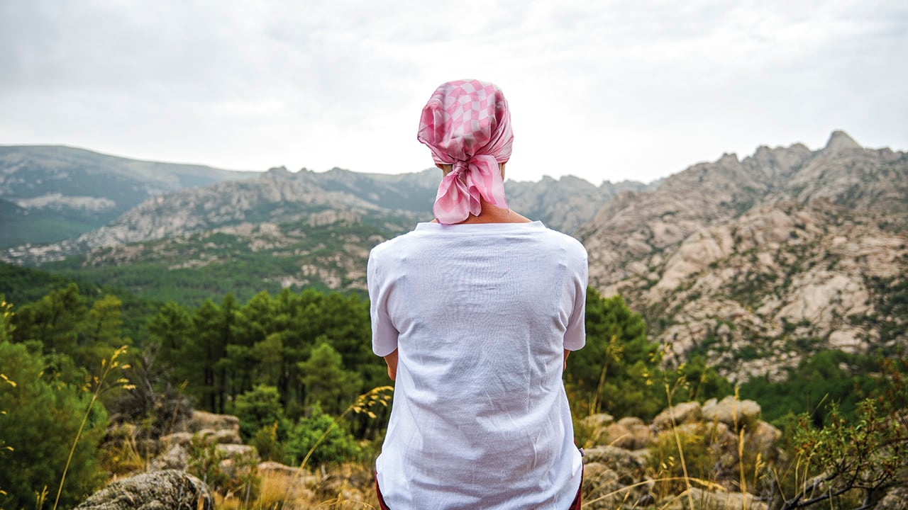 Woman with cancer sitting in a natural space.