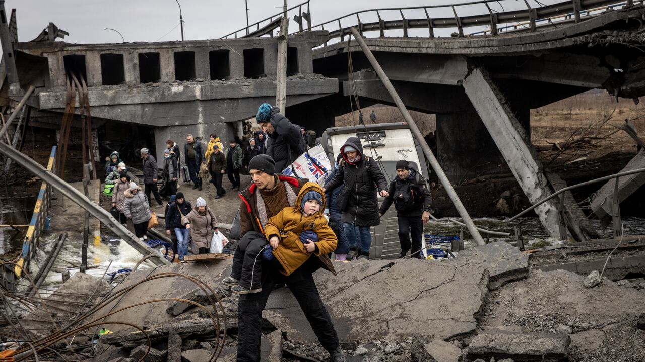 Los residentes de Irpin huyen de los intensos combates a través de un puente destruido cuando las fuerzas rusas ingresaron a la ciudad el 7 de marzo de 2022. (Foto: Chris McGrath/Getty Images)