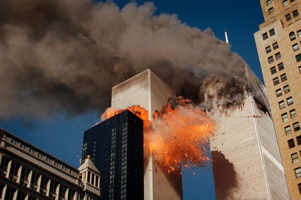 Sale humo a borbotones de una de las torres del World Trade Center mientras llamas y escombros estallan desde la segunda torre, el 11 de septiembre de 2001