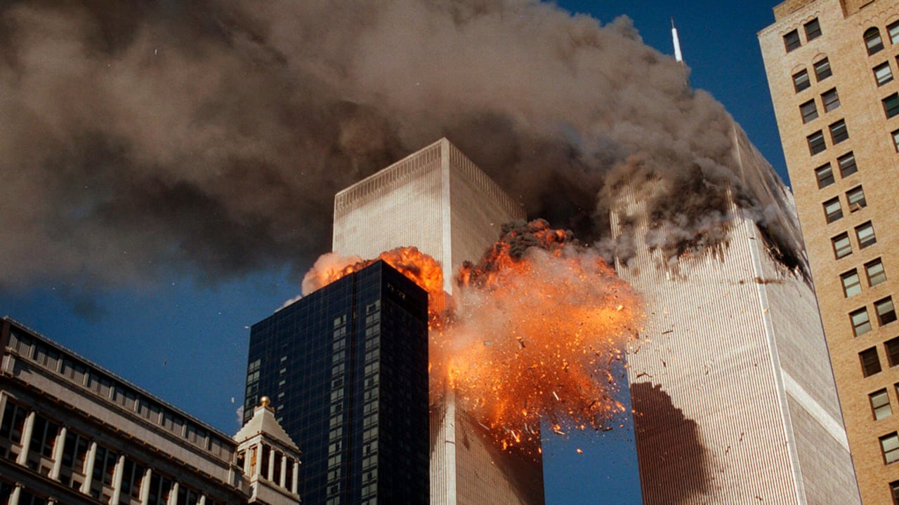 Sale humo a borbotones de una de las torres del World Trade Center mientras llamas y escombros estallan desde la segunda torre, el 11 de septiembre de 2001
