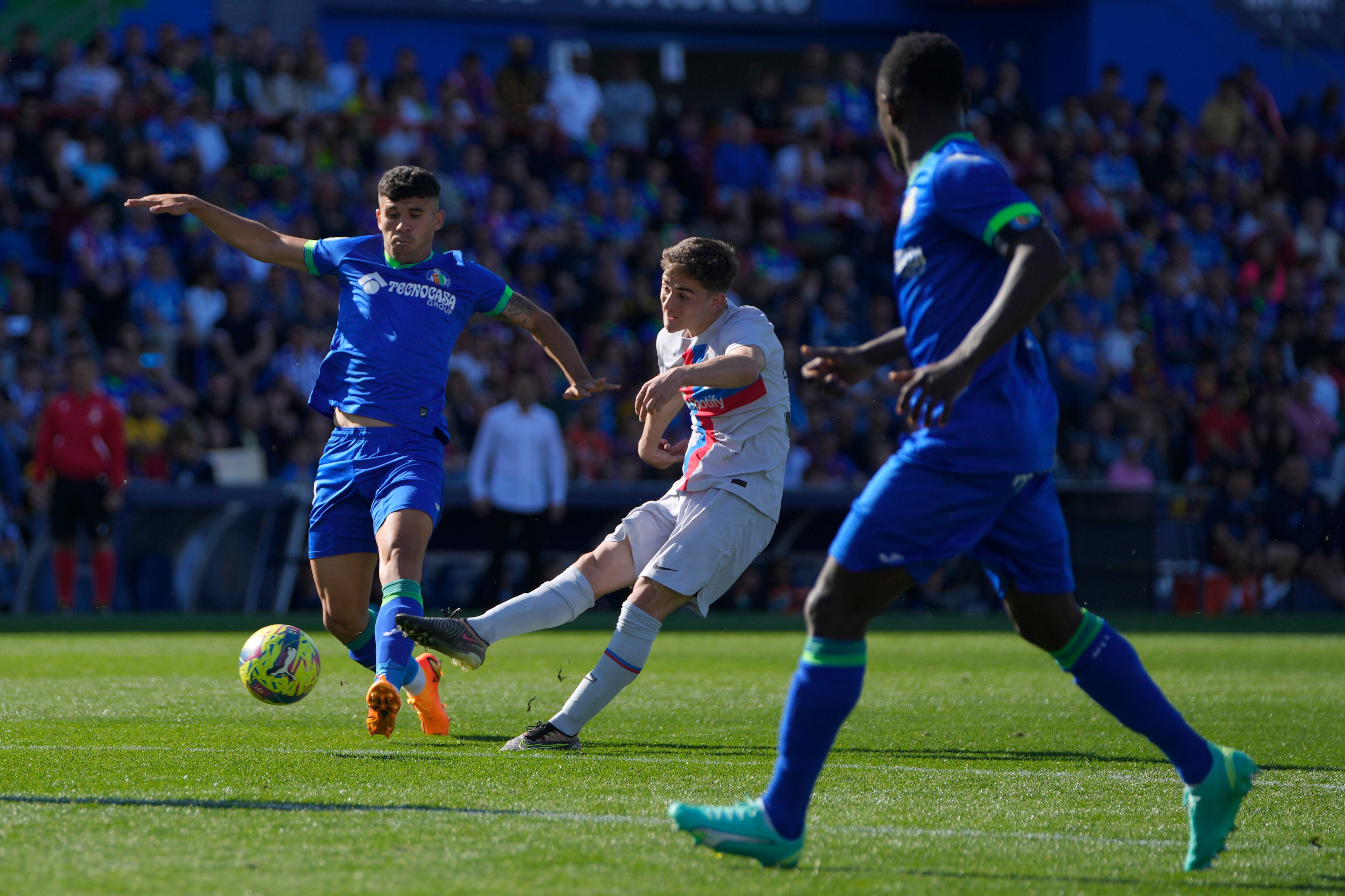 Barcelona's Gavi, centre, attempts a shot at goal in front of Getafe's Munir El Haddadi during a Spanish La Liga soccer match between Getafe and FC Barcelona at the Coliseum Alfonso Perez stadium in Getafe, Spain, Sunday, April 16, 2023. (AP Photo/Manu Fernandez)