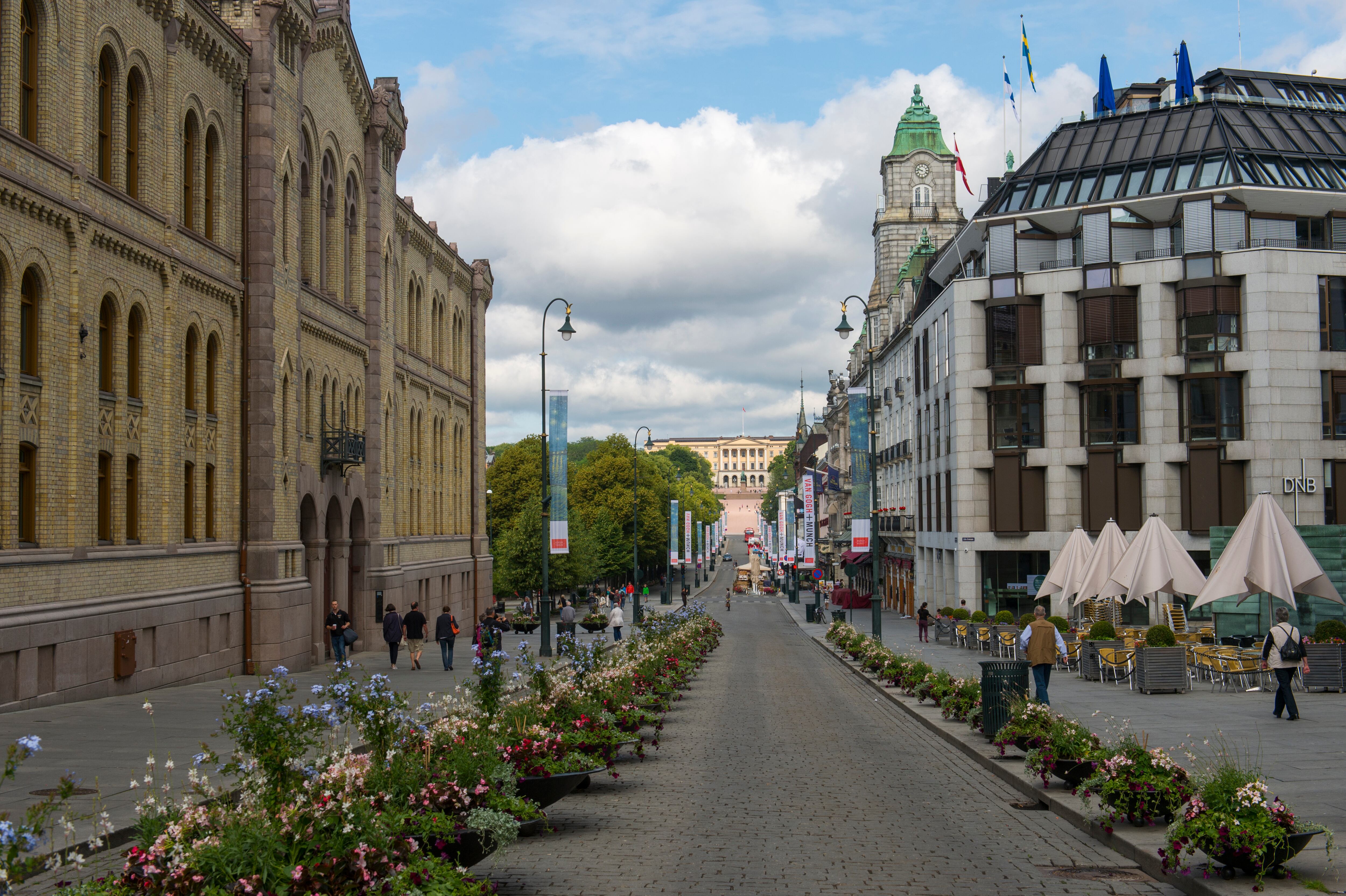 Escena callejera de Karl Johans Gate en Oslo, Noruega, con el palacio real al fondo