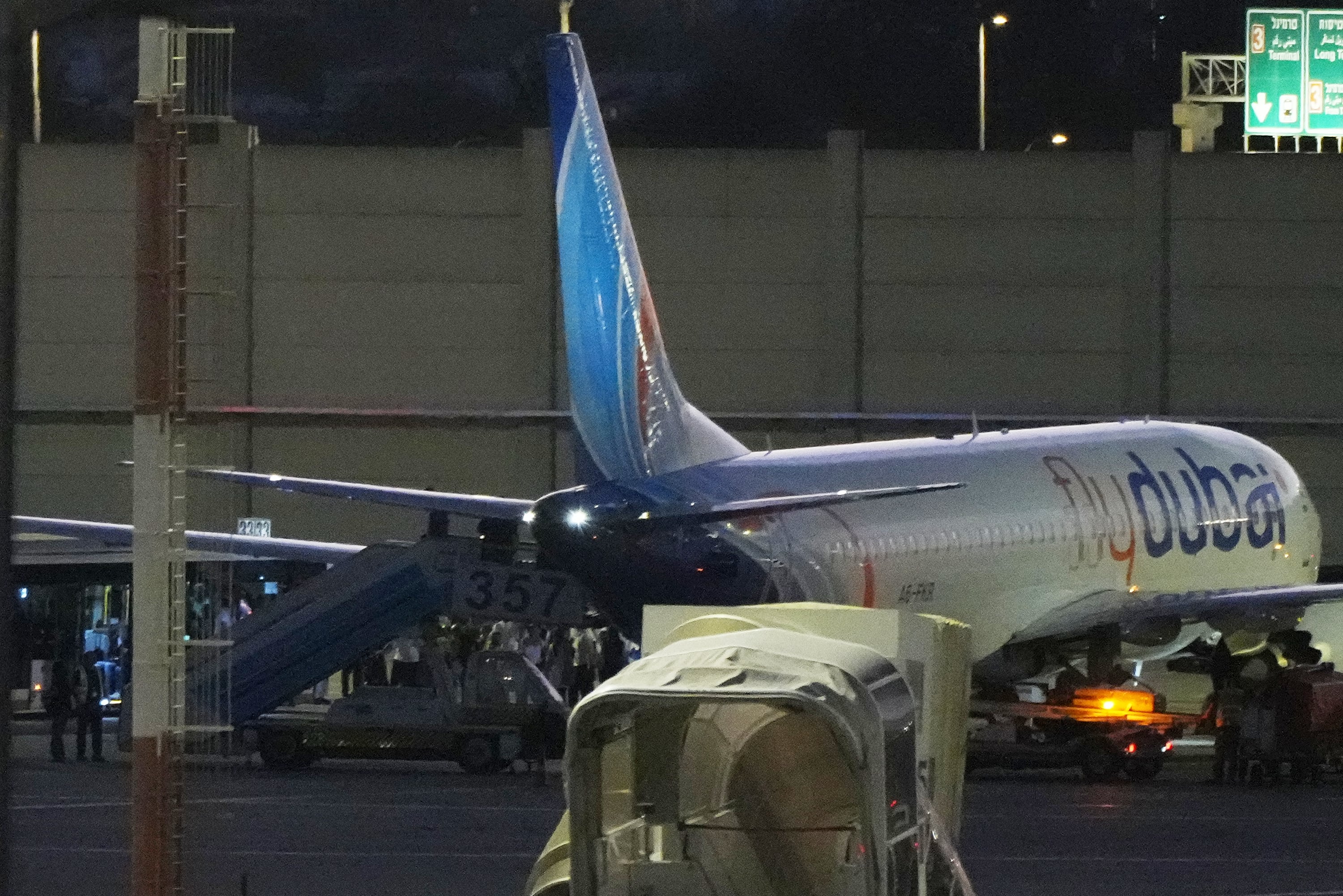 Varias personas desembarcan de un avión de FlyDubai que transportaba a israelíes que sufrieron un aterrizaje de emergencia en Arabia Saudita