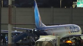 Varias personas desembarcan de un avión de FlyDubai que transportaba a israelíes que sufrieron un aterrizaje de emergencia en Arabia Saudita