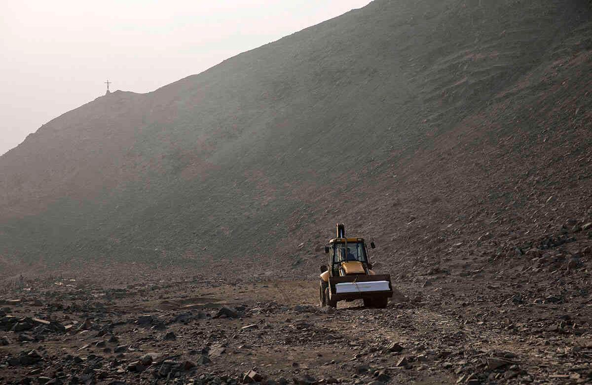 Una retroexcavadora lleva el ataúd que contiene el cuerpo de Vicenta Panduro Panduro, de 87 años, quien murió por complicaciones del Covid-19, hacia su tumba en un cementerio en Carabayllo de Lima, Perú, el martes 25 de agosto. Foto: Rodrigo Abd / AP 