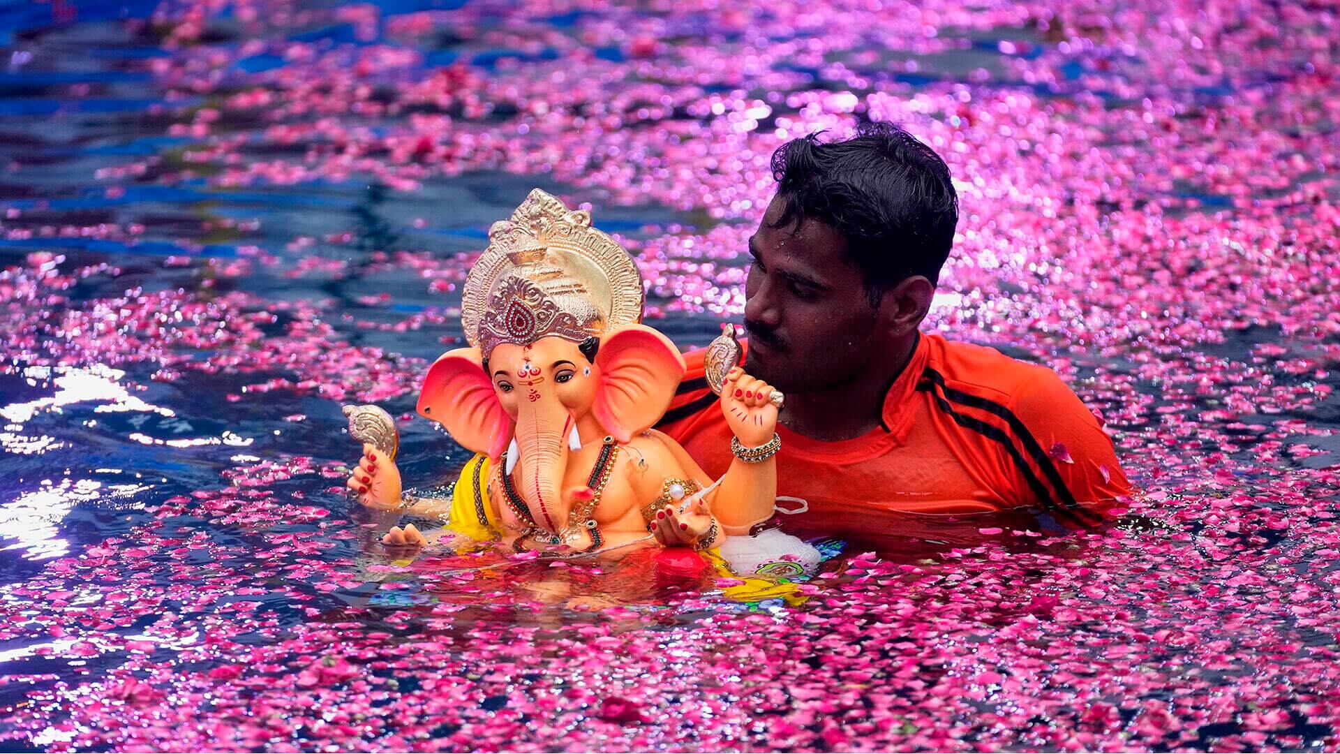 >Un voluntario indio lleva un ídolo del dios hindú Ganesha, con cabeza de elefante, para sumergirse en un estanque artificial de Bombay, India, el jueves 28 de agosto de 2025.