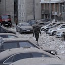 Un agente de policía camina por un estacionamiento con autos dañados, frente a un edificio de varias plantas, luego de un ataque ruso sobre Kiev, en Ucrania, el 30 de mayo de 2023. (AP Foto/Roman Hrytsyna)