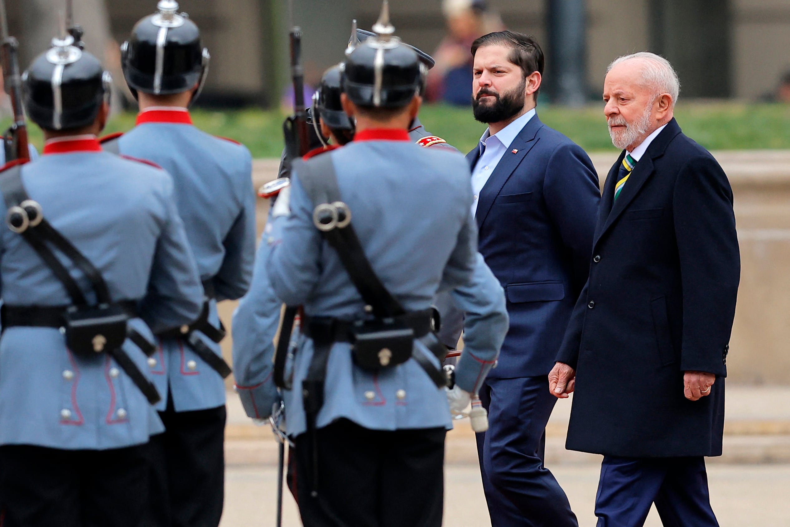 El Presidente de Chile, Gabriel Boric (C), y el Presidente de Brasil, Luiz Inácio Lula da Silva (R), revisan una guardia de honor a su llegada al palacio presidencial de La Moneda en Santiago el 5 de agosto de 2024. Lula da Silva está en visita oficial a Chile para discutir la economía cuestiones y relaciones bilaterales. (Foto de Javier TORRES/AFP)