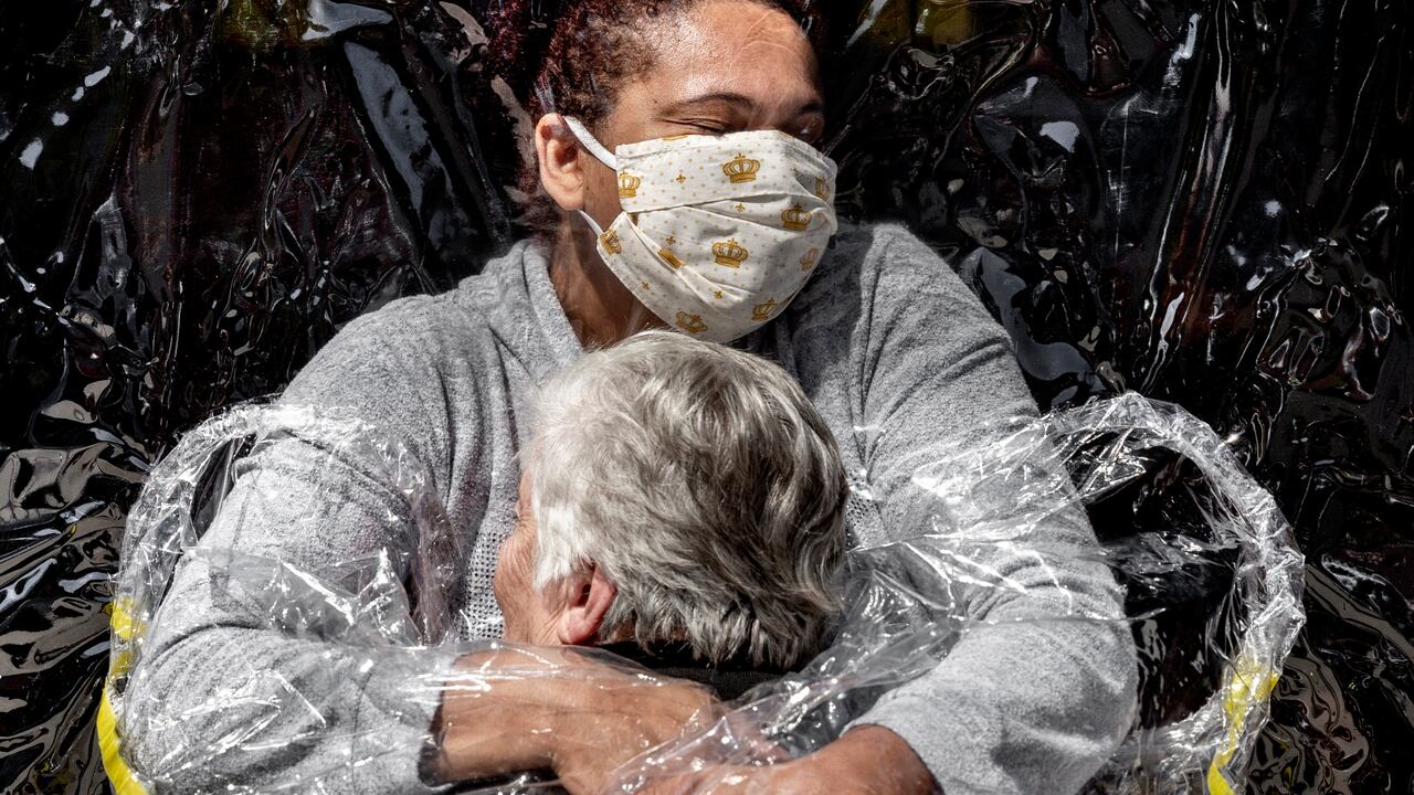 En esta imagen publicada por World Press Photo, el jueves 15 de abril de 2021 es del fotógrafo Mads Nissen (Politiken, Panos Pictures). Ganó el premio World Press Photo of the Year, y el primer premio en la categoría General News Singles. Se titula The First Embrace, muestra a Rosa Luzia Lunardi (85) abrazada por la enfermera Adriana Silva da Costa Souza, en el hogar de cuidados Viva Bem, Sao Paulo, Brasil, el 5 de agosto de 2020. Crédito: Mads Nissen, Politiken, Panos Pictures, World Press Photo vía AP