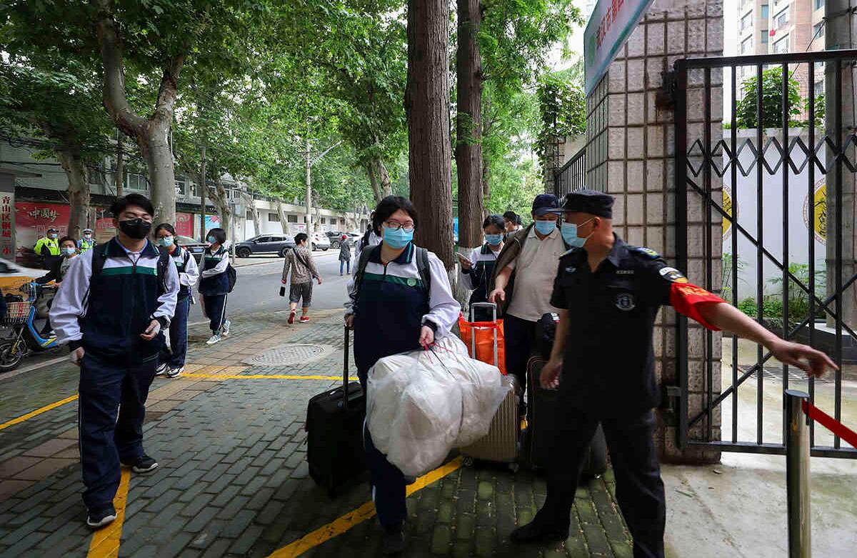 Los estudiantes con tapabocas llegan a una escuela secundaria en Wuhan, en la provincia de Hubei, en el centro de China. Los estudiantes mayores regresaron a clases el miércoles en la ciudad de Wuhan, en el centro de China. Andy Wong / AP