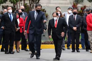 Con una máscara en medio de la pandemia de COVID-19, el presidente peruano Martín Vizcarra, a la izquierda, camina con su abogado Fernando Ugaz mientras sale del palacio de gobierno para el Congreso en Lima, Perú. Foto: AP / Martín Mejía.
