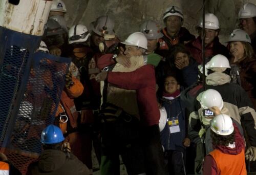 El minero Florencio Ávalos (en el centro a la izq.) abraza al presidente chileno Sebastián Piñera hoy miércoles 13 de octubre de 2010, al salir de la mina San José, cerca de Copiapó (Chile), tras 69 días atrapado. Ávalos fue el primer minero en salir a la superficie a las 0:10 horas del miércoles (03:10 GMT) al término de una maniobra seguida en directo por televisión por mil millones de espectadores alrededor del mundo. 