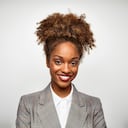 Portrait of beautiful young woman with curly hair. Confident female is smiling. She is against white background.