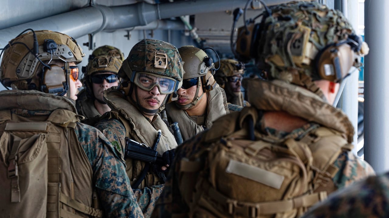 Esta imagen, tomada de un video proporcionado por el Comando Central de Estados Unidos, muestra a marineros e infantes de marina estadounidenses a bordo del USS Tripoli llegando al área de responsabilidad del Comando Central.