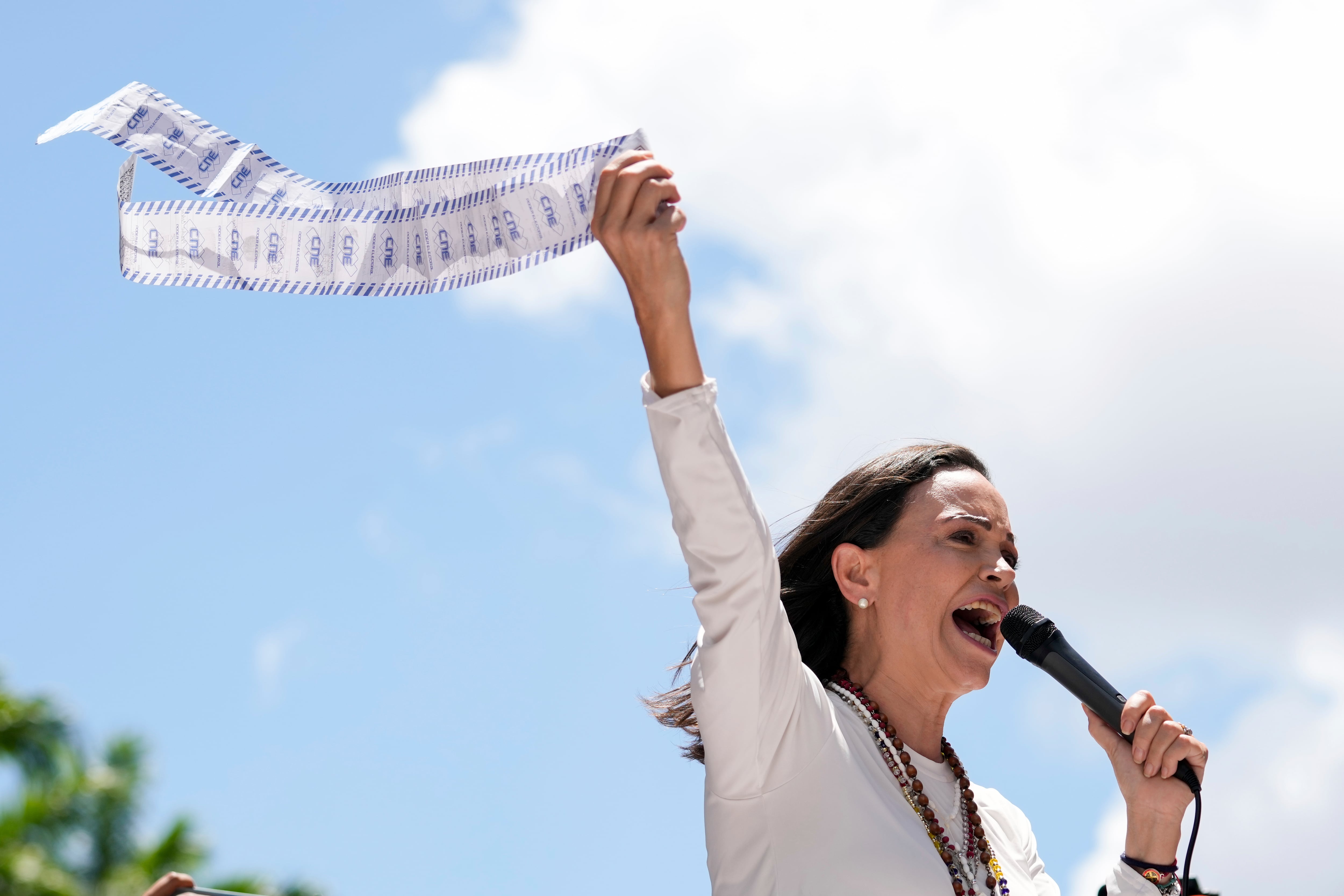 La líder de la oposición María Corina Machado muestra actas de recuento de votos durante una protesta contra la reelección del presidente Nicolás Maduro un mes después de la disputada votación presidencial que, según ella, la oposición ganó por abrumadora mayoría, en Caracas, Venezuela, el miércoles 28 de agosto de 2024. (AP Foto/Ariana Cubillos)