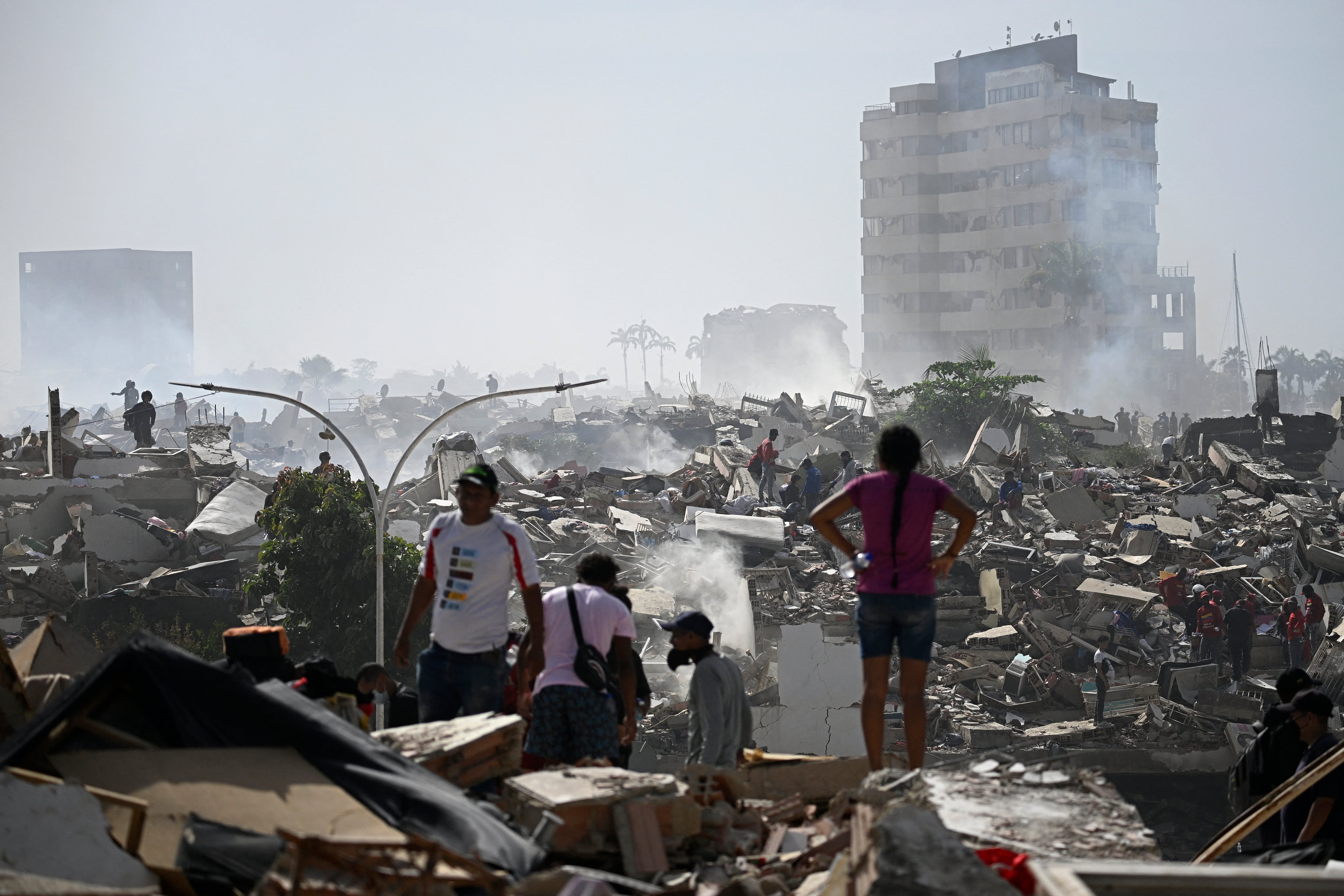Voluntarios buscan posibles víctimas entre los escombros de un edificio derrumbado tras el doble terremoto que sacudió Caraballeda, estado de La Guaira, a unos 40 km al noreste de Caracas, el 25 de junio de 2026. El número de fallecidos por los sismos, de magnitud 7.2 y 7.5, asciende a al menos 188, con más de 1520 heridos, según informó el diputado Jorge Rodríguez, mientras los residentes continúan la búsqueda de familiares desaparecidos. (Foto de Federico PARRA / AFP)