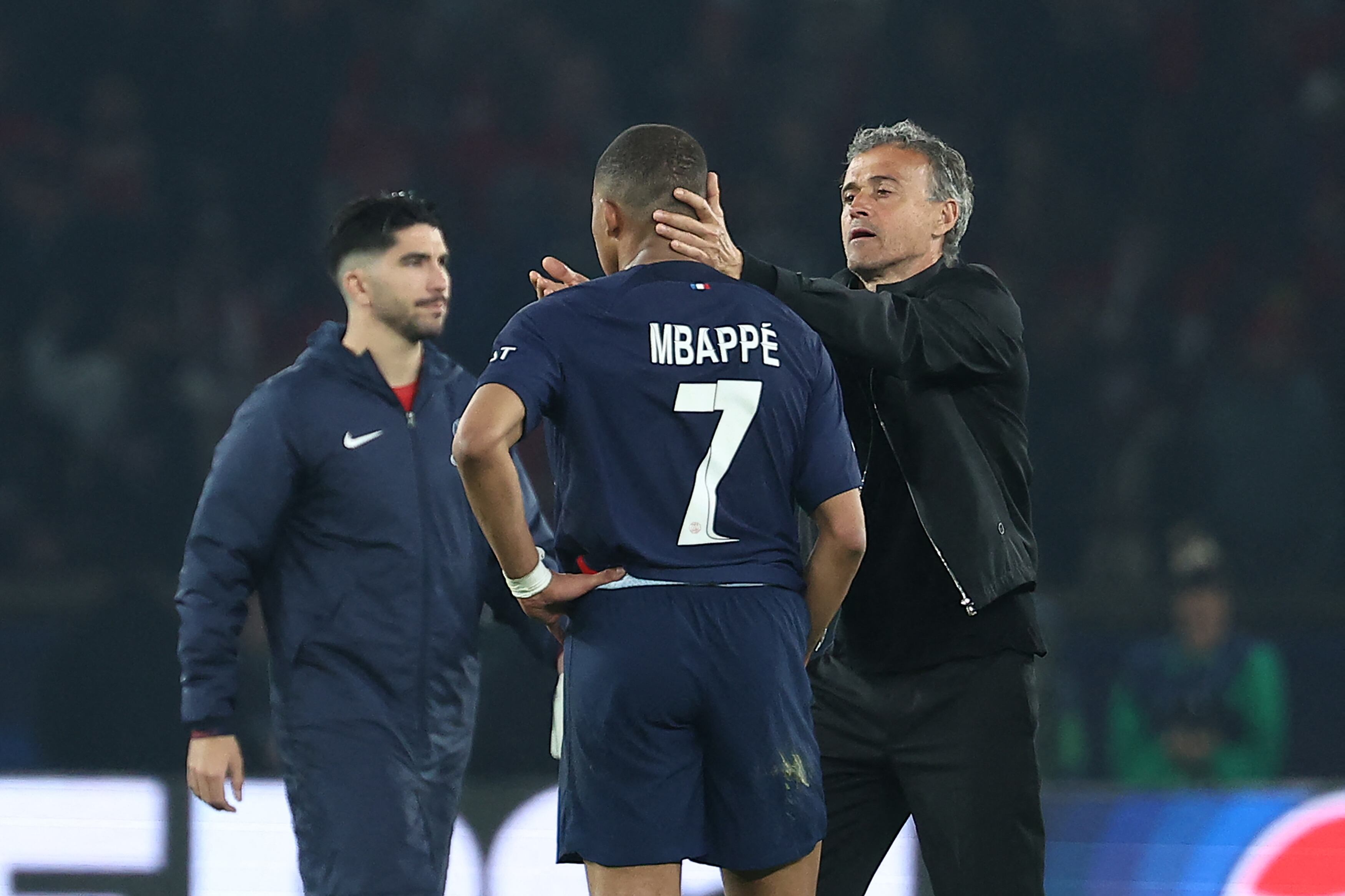Paris Saint-Germain's Spanish headcoach Luis Enrique (R) consoles Paris Saint-Germain's French forward #07 Kylian Mbappe (C) at the end of the UEFA Champions League semi-final second leg football match between Paris Saint-Germain (PSG) and Borussia Dortmund, at the Parc des Princes stadium in Paris on May 7, 2024. (Photo by FRANCK FIFE / AFP)