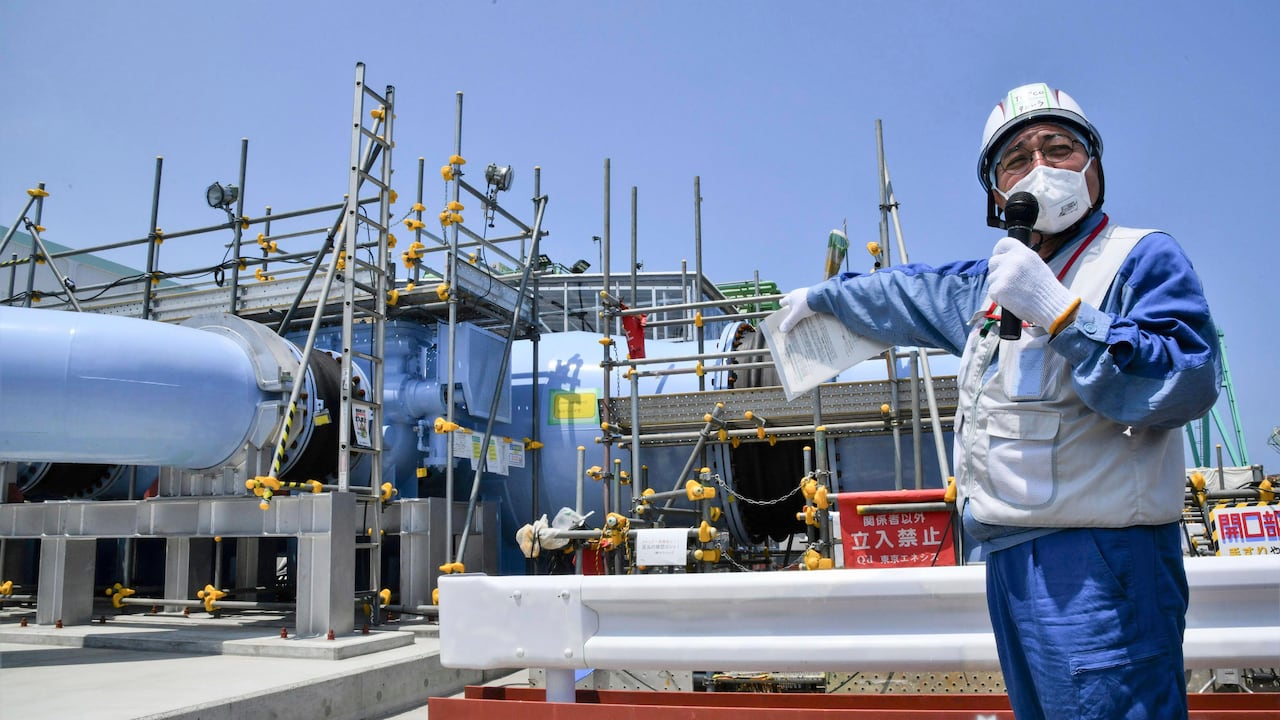 Un empleado del operador de la planta nuclear Fukushima Daiichi, Tokyo Electric Power Company Holdings (Tepco), explica la instalación que se utilizará para liberar al mar el agua radiactiva y tratada el lunes 26 de junio de 2023, en esa planta de Fukushima, en el norte de Japón. (Kyodo News vía AP)