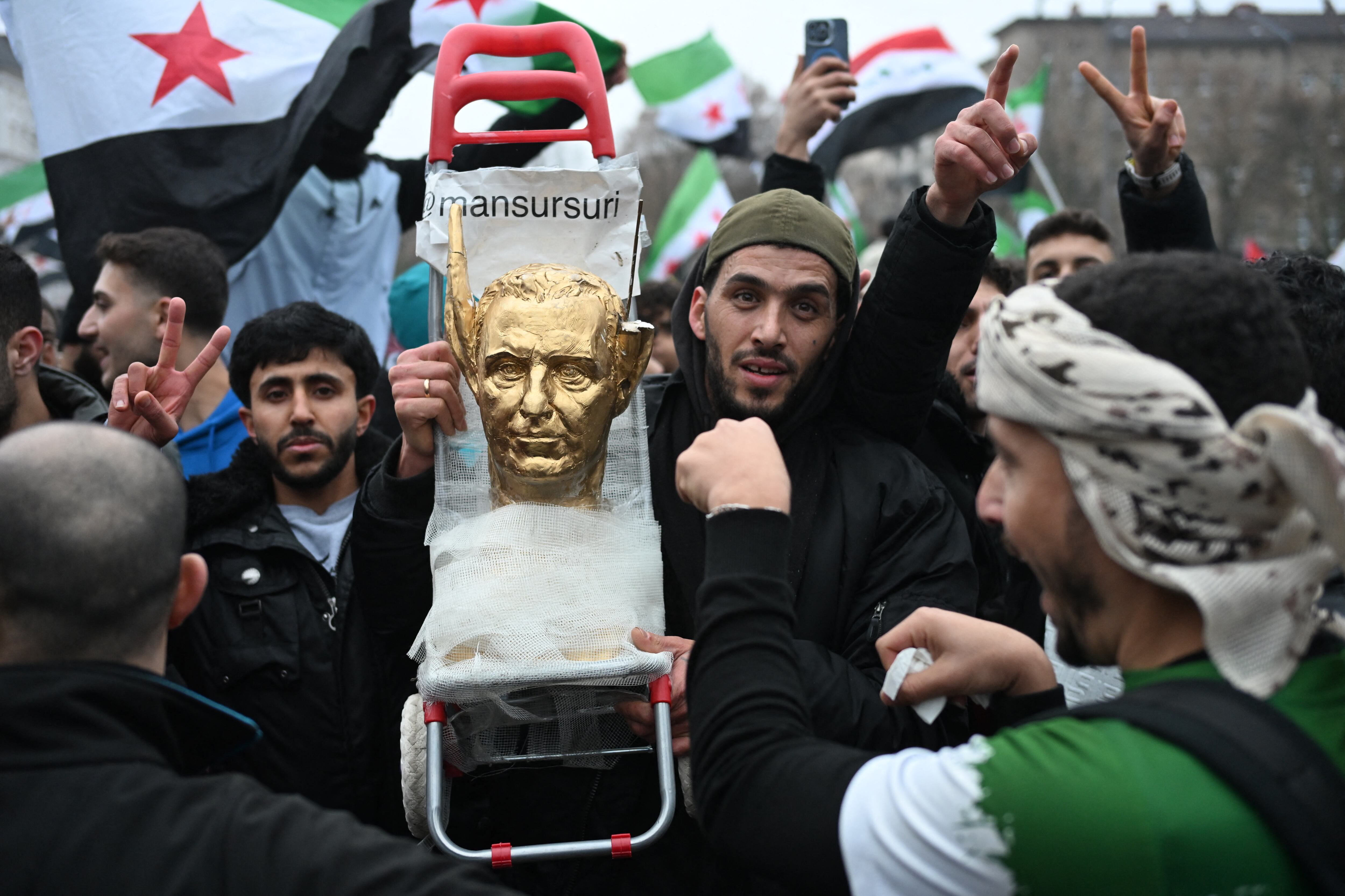 Un manifestante sostiene un busto pintado de oro del dictador sirio Bashar al-Assad con orejas de burro mientras miembros de la comunidad siria se concentran el 8 de diciembre de 2024 en Berlín, Alemania, para celebrar el fin del gobierno del dictador sirio