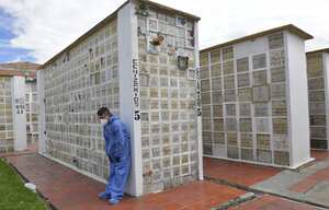 Un empleado de la Fundación Jardín del Cementerio Fontibón descansa durante la cremación de una víctima del covid-19 en Bogotá.