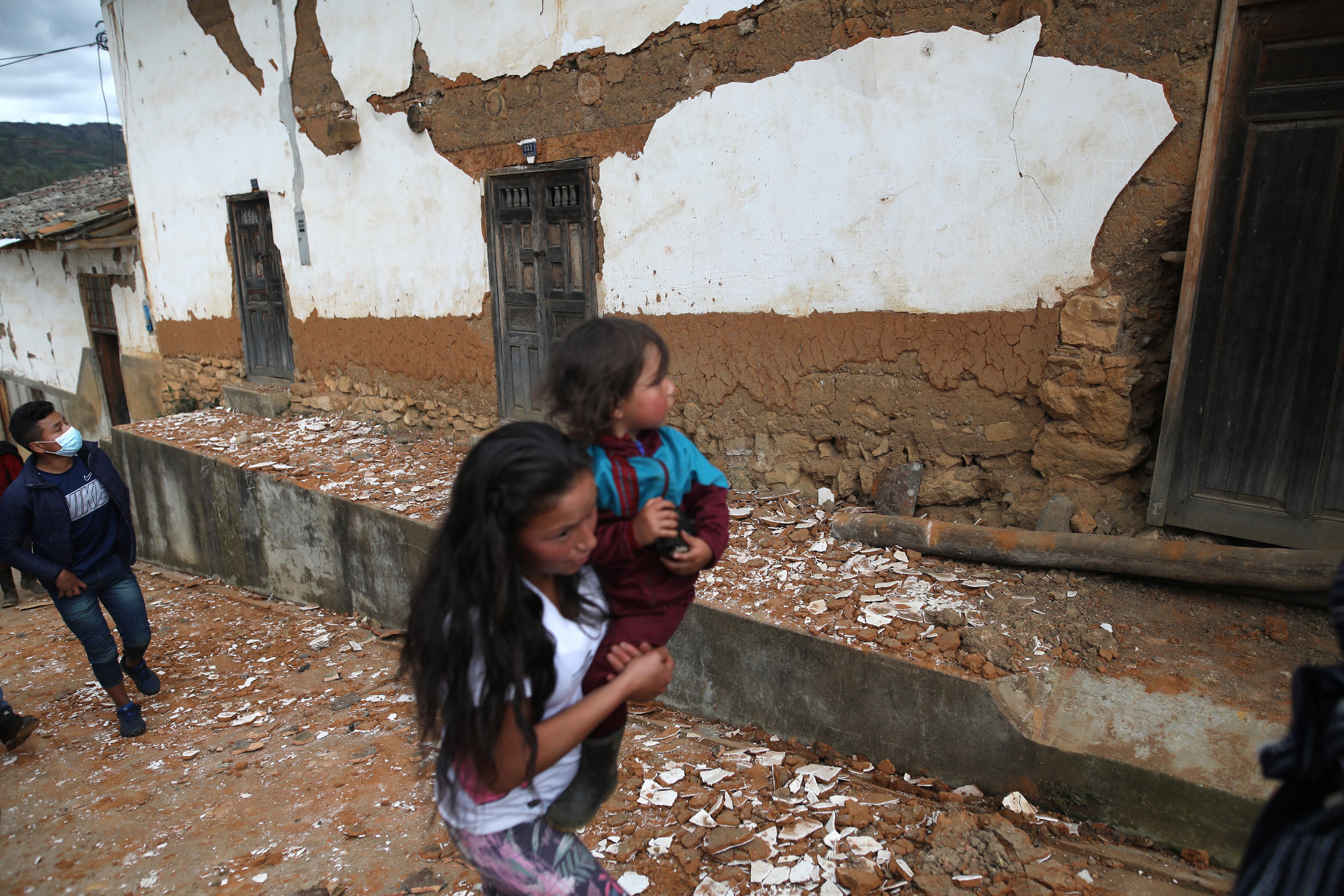Una niña camina junto a los restos de una casa destruida por un terremoto en el departamento de Amazonas, noreste de Perú, el 28 de noviembre de 2021. - Un fuerte terremoto de magnitud 7.5 sacudió el domingo la selva norte de Perú y una vasta área alrededor del costa central del país, dejando dos heridos y daños materiales, según autoridades. (Foto Presidencia Peruana / AFP) / RESTRINGIDO A USO EDITORIAL-CRÉDITO OBLIGATORIO - FOTO AFP / PRESIDENCIA PERUANA / ALDAIR MEJIA- NO MAFRKETING - NO CAMPAÑAS PUBLICITARIAS - DISTRIBUIDO COMO SERVICIO A CLIENTES