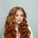 Beauty fashion portrait of beautiful cheerful smiling redhead woman with long ginger hair on white background