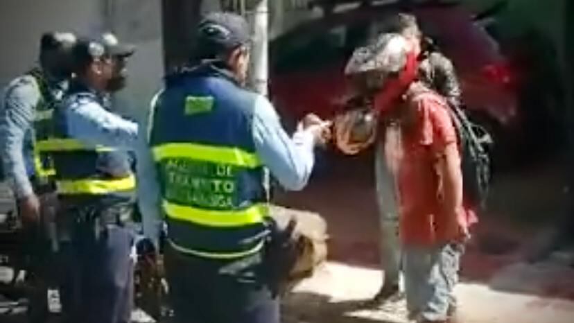 El hombre de casco y suéter color rojo golpeo al agente de tránsito