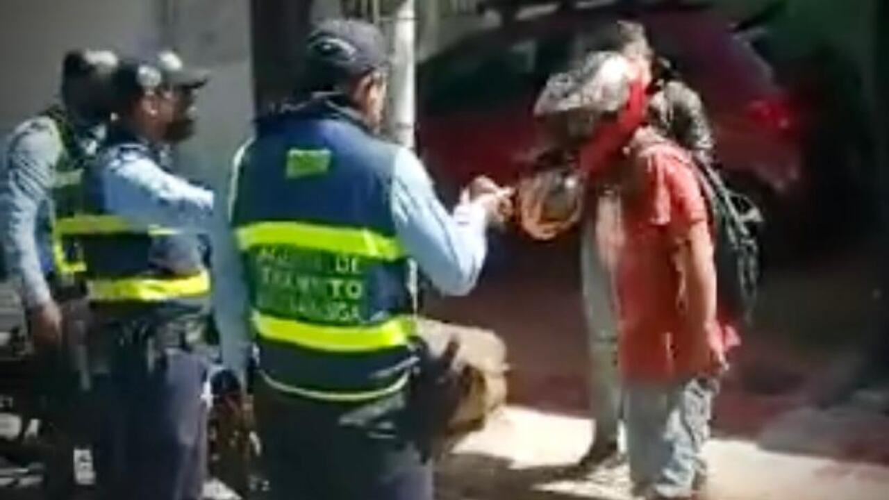 El hombre de casco y suéter color rojo golpeo al agente de tránsito